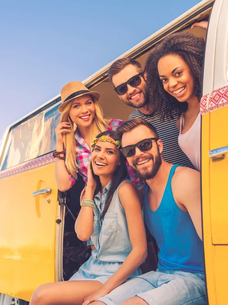 Young people smiling inside of retro mini van