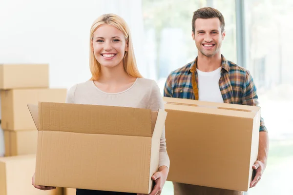 Cheerful couple holding cardboard boxes