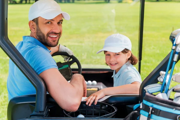 Man and his son sitting in golf cart