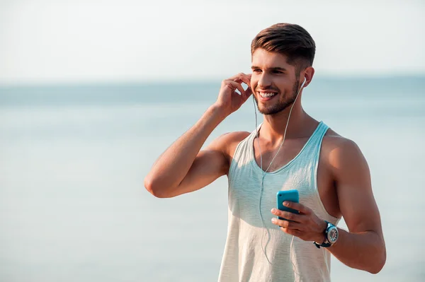 Man in headphones holding smart phone