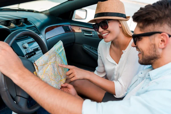 Couple examining map  in convertible