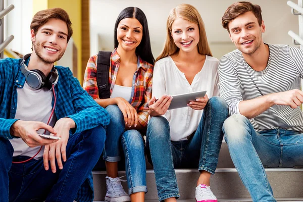 Happy young people sitting on the stairs