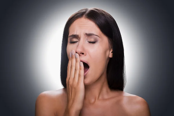 Woman covering mouth by hand and yawning