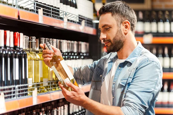 Man holding bottle of wine in store