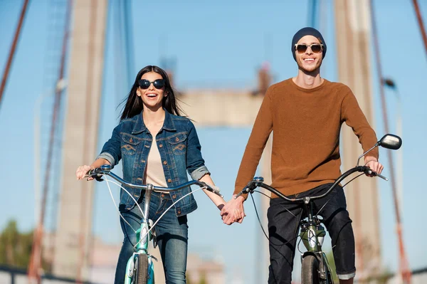 Couple riding bicycles along the bridge