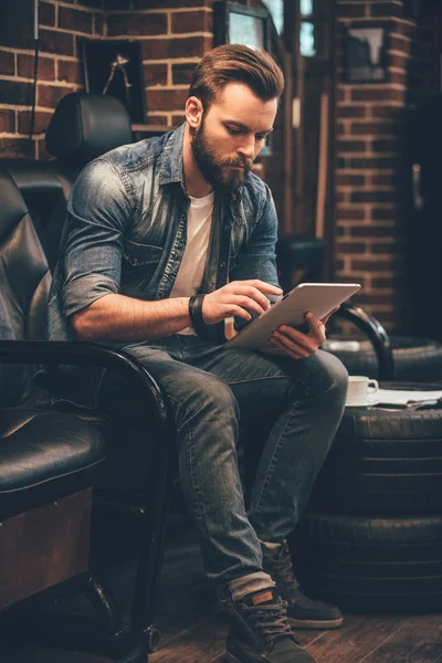 Bearded man working on digital tablet