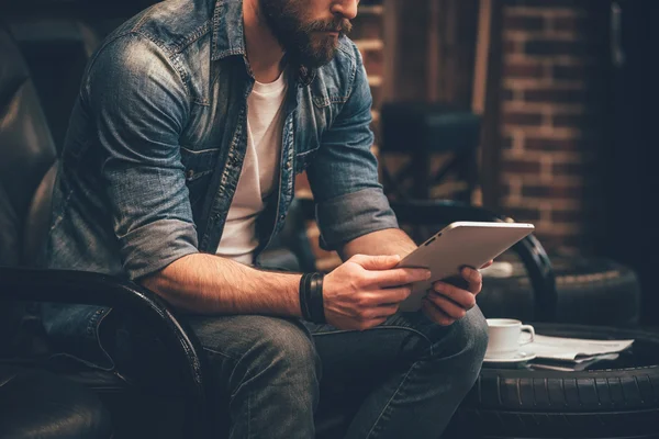 Bearded man working on digital tablet