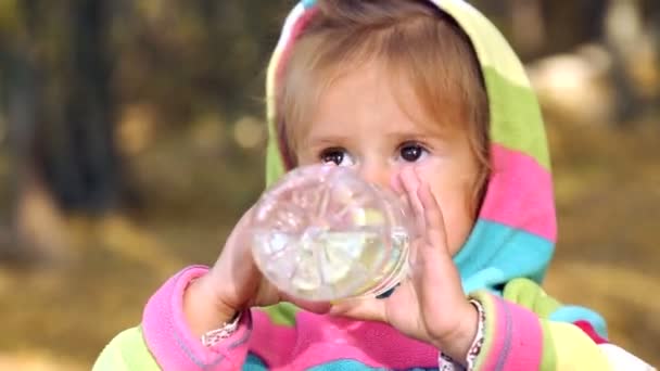 孩子喝矿泉水。小女孩正在喝水的性质。小女孩