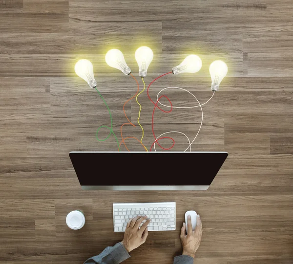 Working on desktop computer with creative light bulb ideas