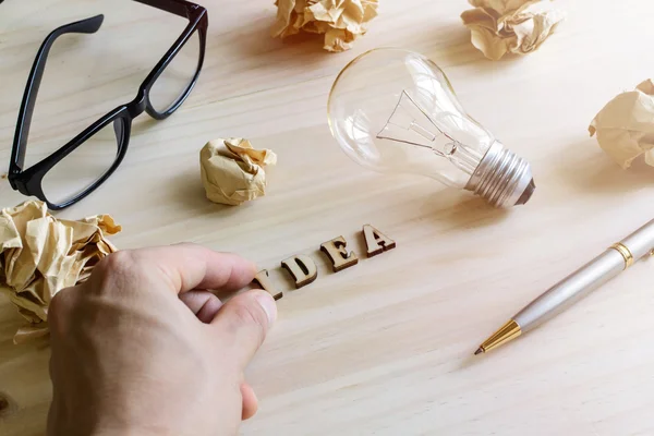 Crumpled paper balls with eye glasses and pen on wooden desk