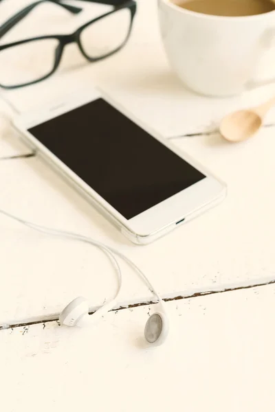 Cellphone and earphone with a cup of coffee