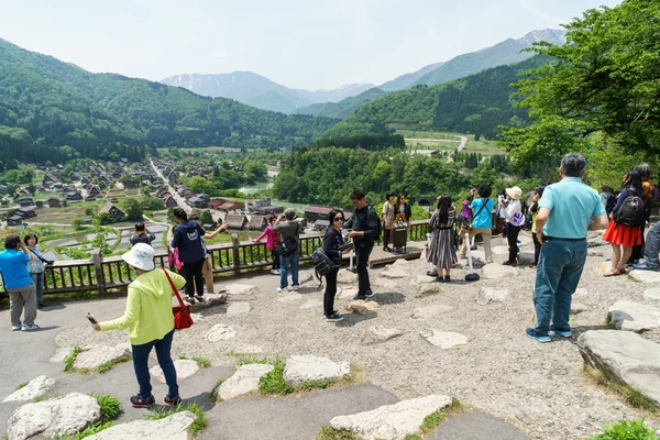 Tourists visit viewpoint of old village Shirakawa-go, Japan.