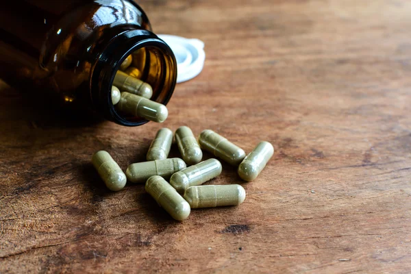 Herb capsule spilling out of bottle