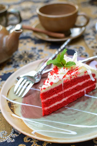 Red velvet cake with cup of tea and kettle