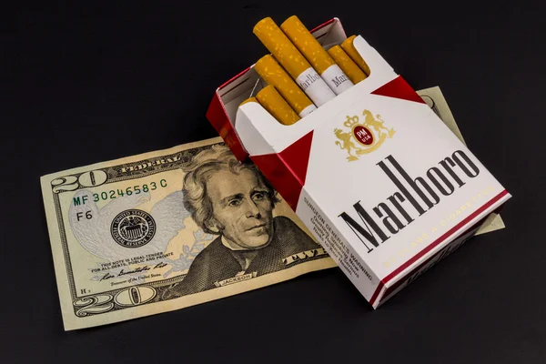 Indianapolis - Circa August 2016: Marlboro Cigarettes and Twenty Dollar Bills Representing the High Costs of Smoking. Marlboro is a product of the Altria Group V