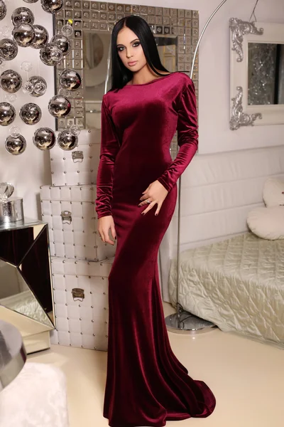 Beautiful sensual woman  with dark hair wears elegant dress,posing in bedroom