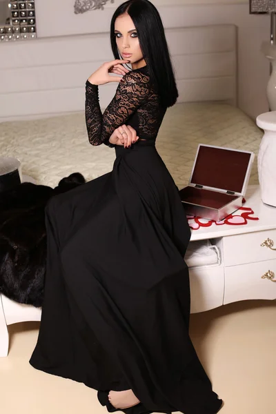 Beautiful sensual woman  with dark hair wears elegant dress,posing in bedroom