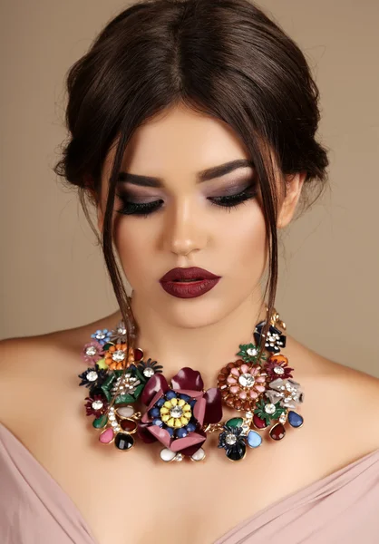 Sexy woman with dark hair and bright makeup, with necklace