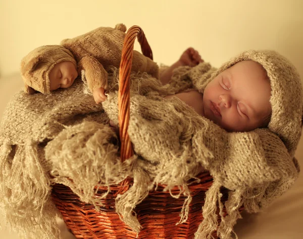 Newborn baby girl sleeping under cozy blanket in basket