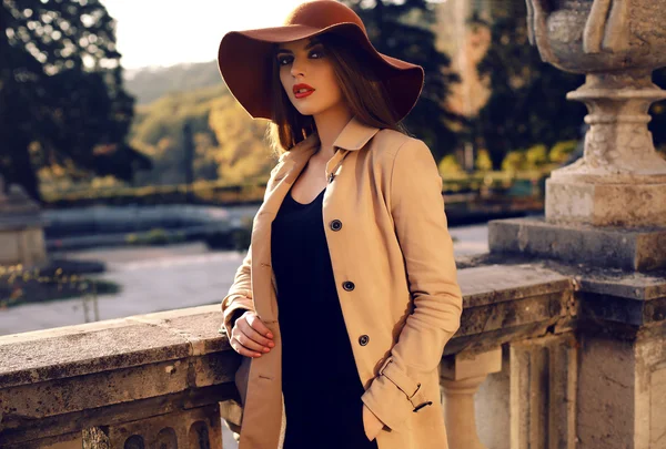 Beautiful girl in elegant fashion clothes posing in autumn park