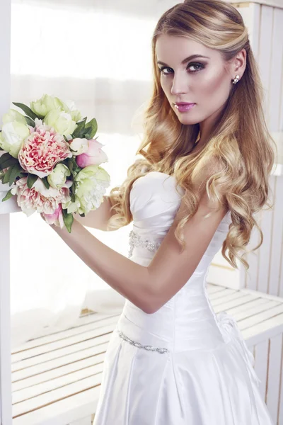 Portrait of beautiful bride in elegant dress with wedding bouquet