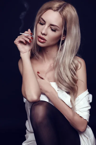 Sexy woman with blond hair in white shirt,smoking cigarette