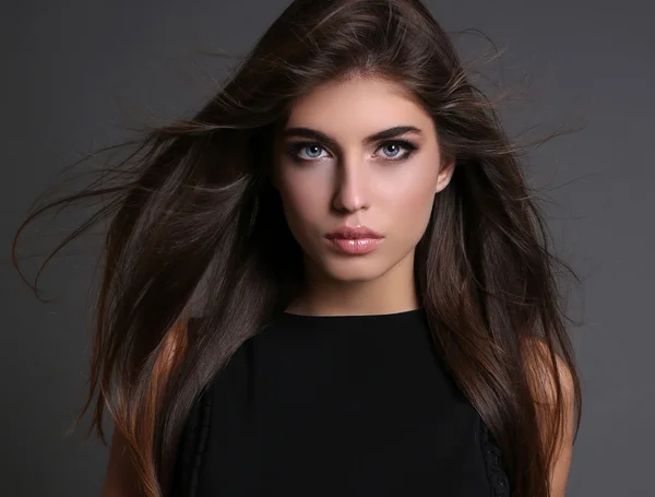 Gorgeous sensual woman with dark straight hair wears elegant clothes