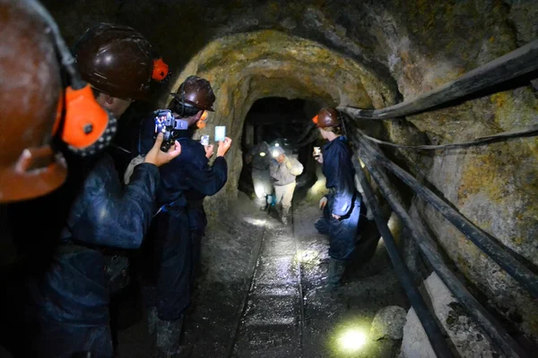 Tourists film miners inside of Cerro Rico mine in Potosi, Bolivia
