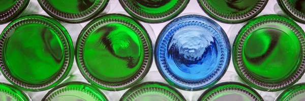 Glass blue bottle among green bottles