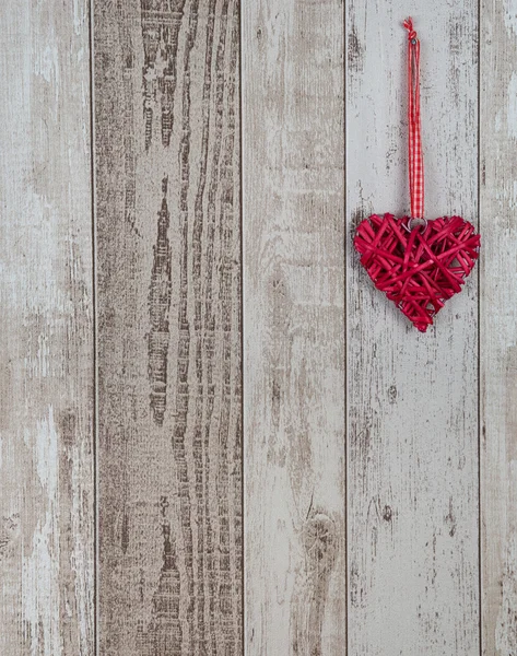 Red wood heart hanging on wooden background