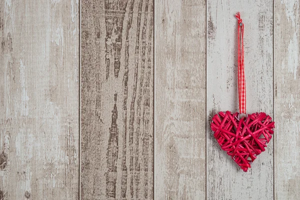 Red wood heart hanging on wooden background