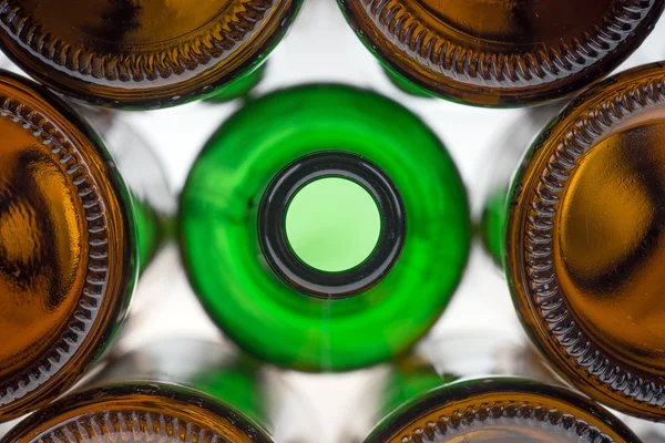 Glass green bottle among brown bottles