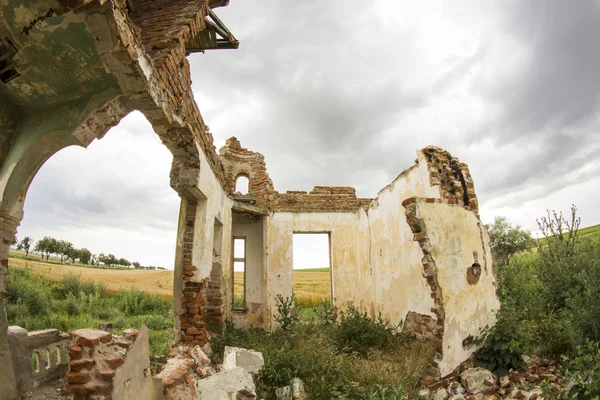 Parts of a ruined house with dramatic sky - different textures and herbs. Fisheye lens effect