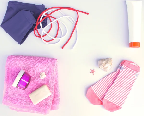 Swimsuit, towel, socks, lotion, and soap on a bright background. Flat lay, top view
