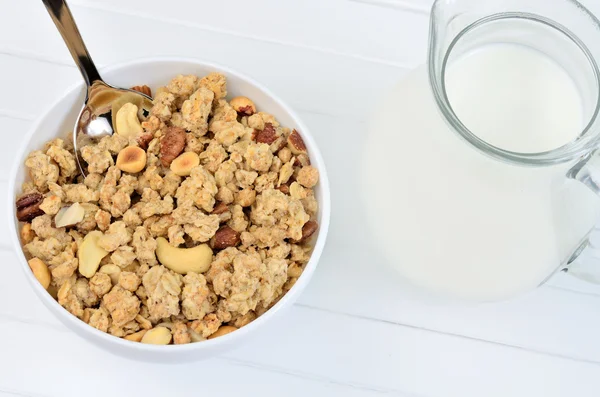 Muesli in ceramic bowl and pitcher with milk