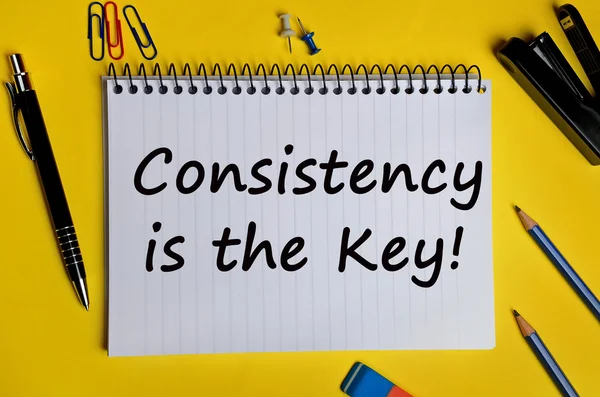 The words Consistency is the key on notebook