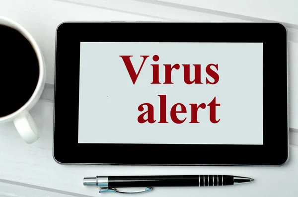 The words Virus alert on digital tablet