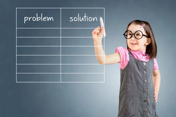 Cute little girl wearing business dress and writing problem and solution list in blank. Blue background.