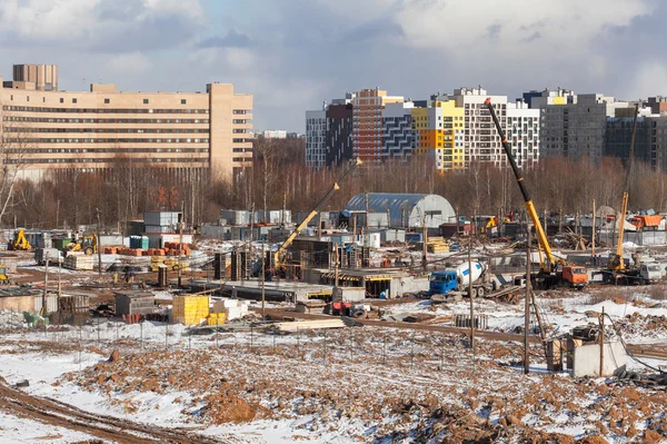 The construction site of the future apartment house in the winter against the backdrop of modern buildings.