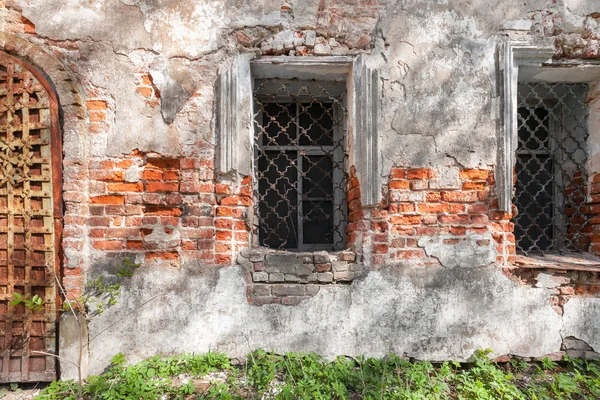 Vintage window with iron bars on the wall of an abandoned temple