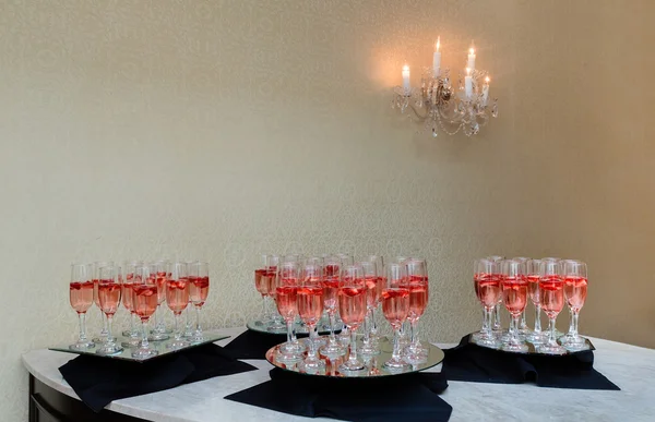 Festive champagne flutes filled with sparkling wine and floating strawberries romantic twinkling party lights