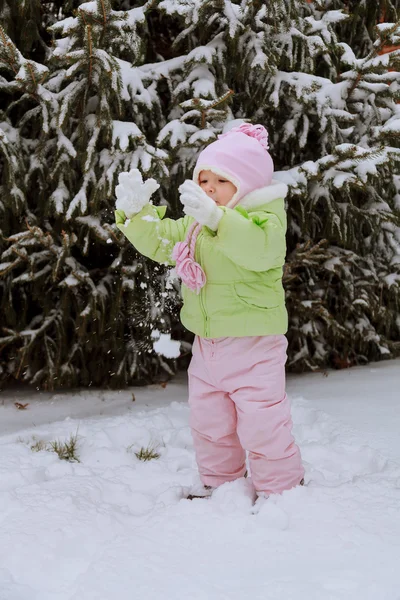 Little girl playing with snow