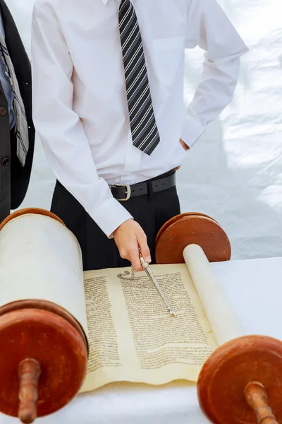 Hand of boy reading the Jewish Torah at Bar Mitzvah
