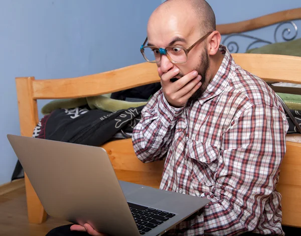 Surprised nerd reading a laptop