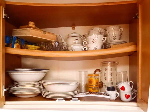 Kitchen cabinet with plates and glasses on the shelf