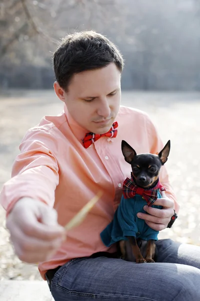 Young hipster play with his toy terrier