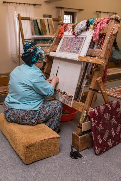 Turkish woman making wool a carpet