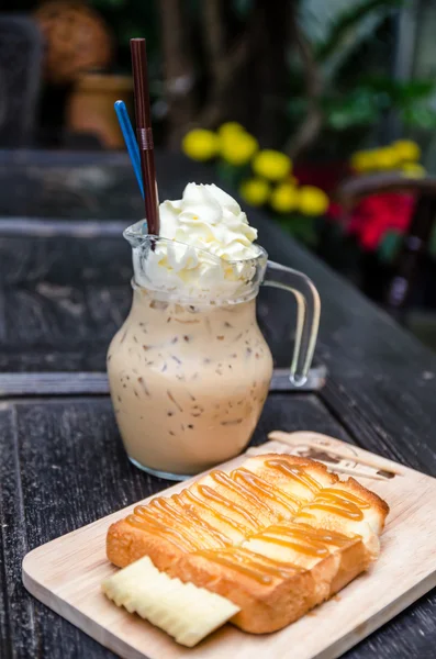 Ice coffee with toast topped with caramel syrup