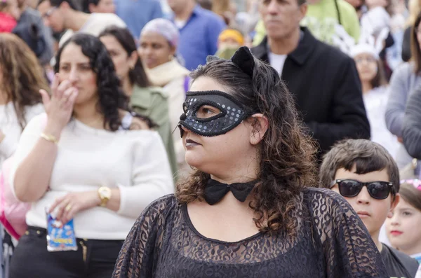 Beer-Sheva, ISRAEL - March 5, 2015: Portrait of a young woman in a black mask in a crowd -Purim