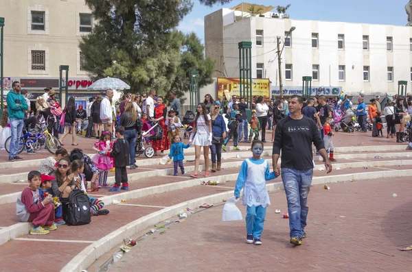 Beer-Sheva, ISRAEL - March 5, 2015:  Children in carnival costumes with their parents on the street in celebration of Purim